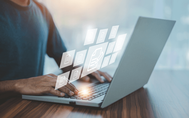 Person working in a laptop, document management concept.